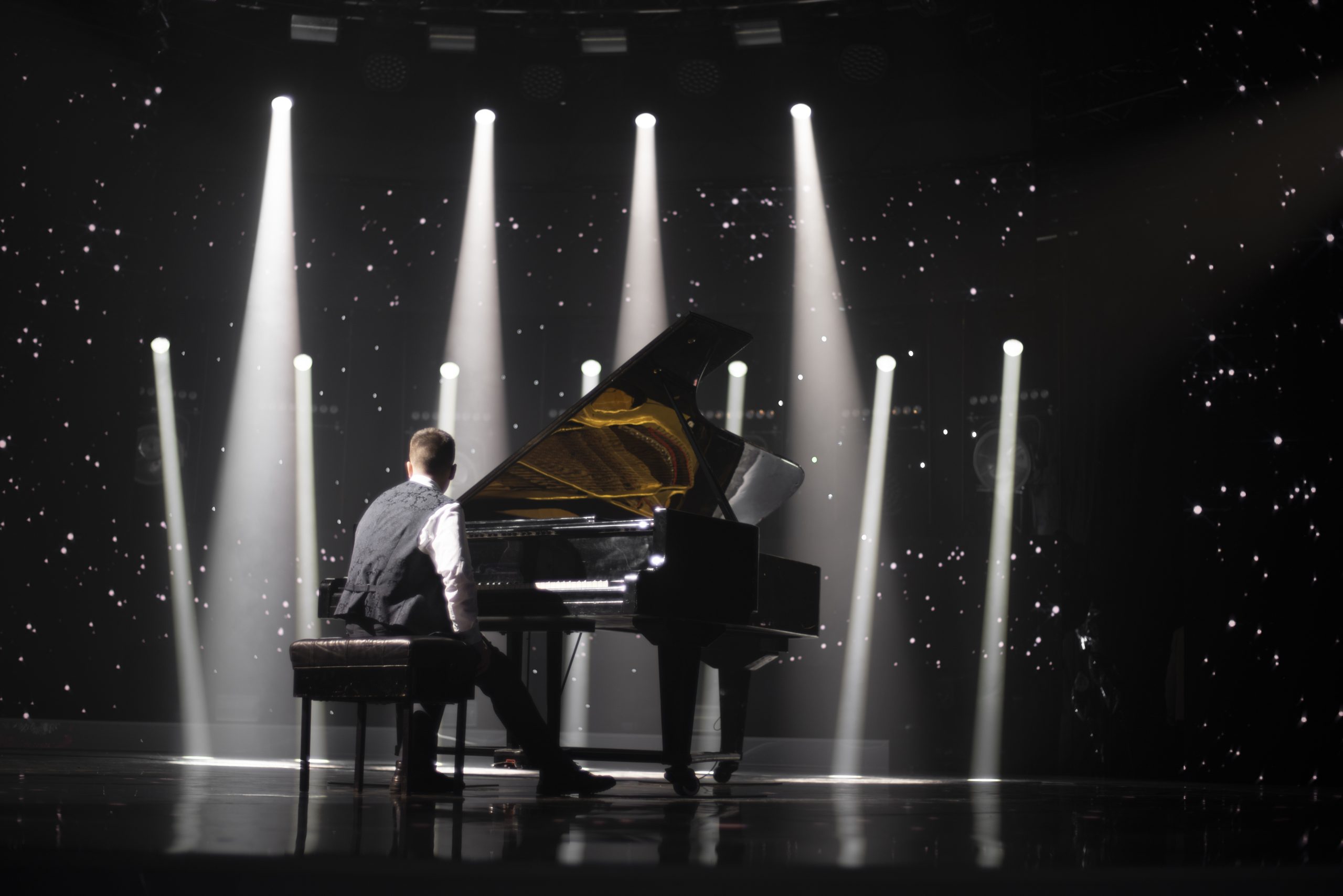 piano player on stage with spotlights