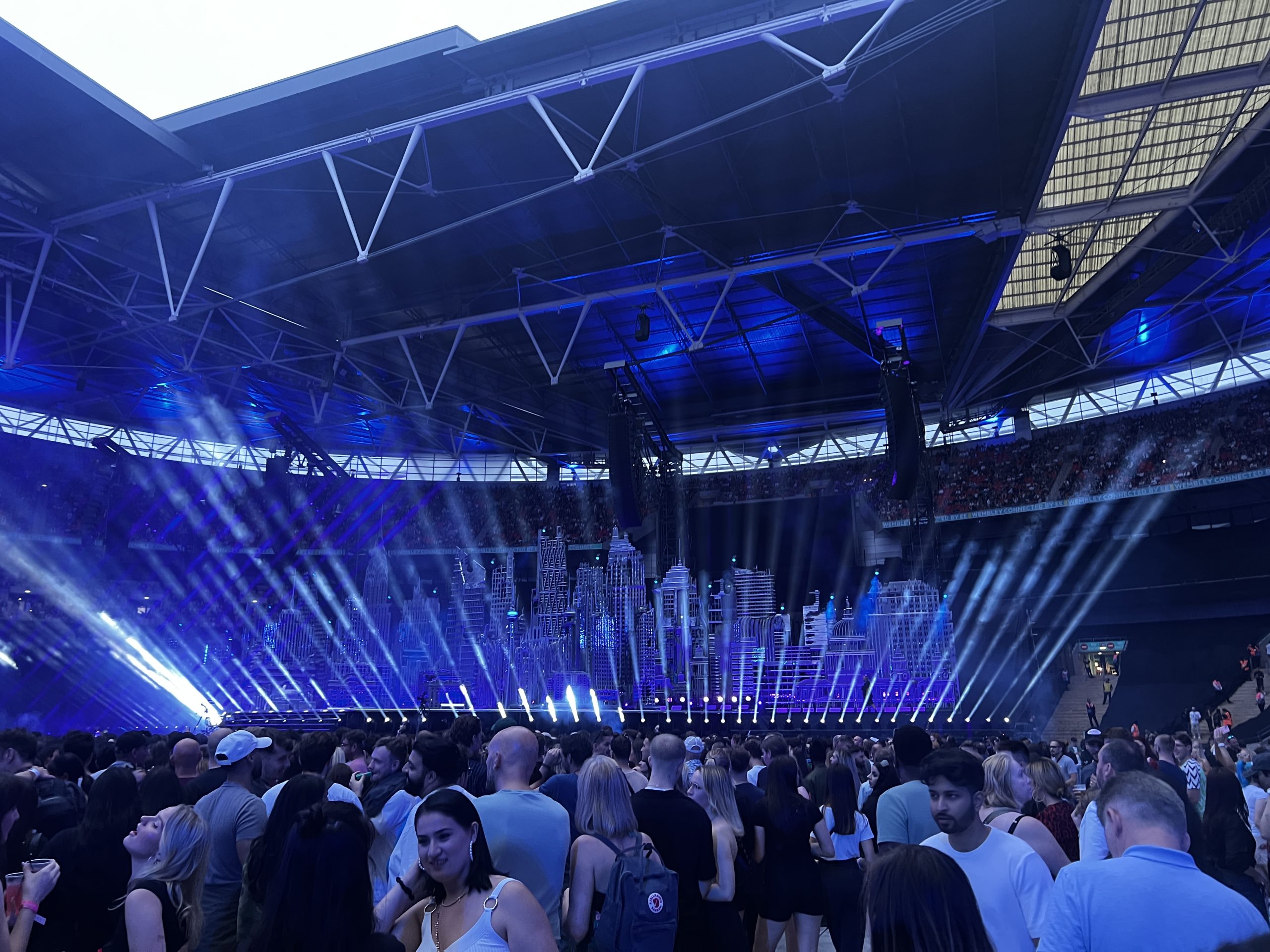 taken from the crowd showing the stage with beams of light in the sky