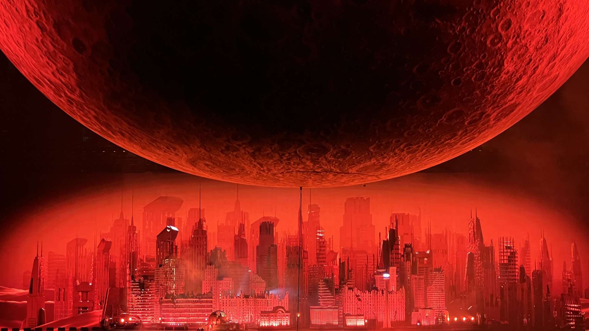 city landscape with a red light and a planet in the sky