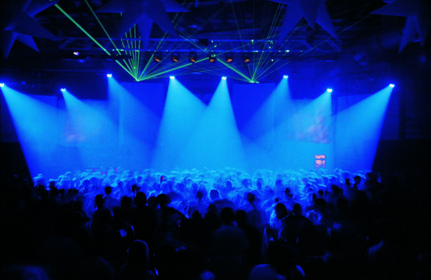 Arena show with crowd and light beams for the stage and laser hitting the crowd