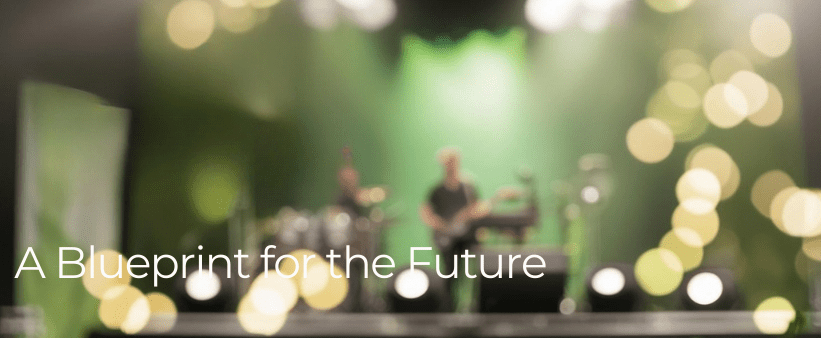 Blurred band on stage with green lights and bokeh effects. Text reads: "A Blueprint for the Future." Energetic and atmospheric scene.